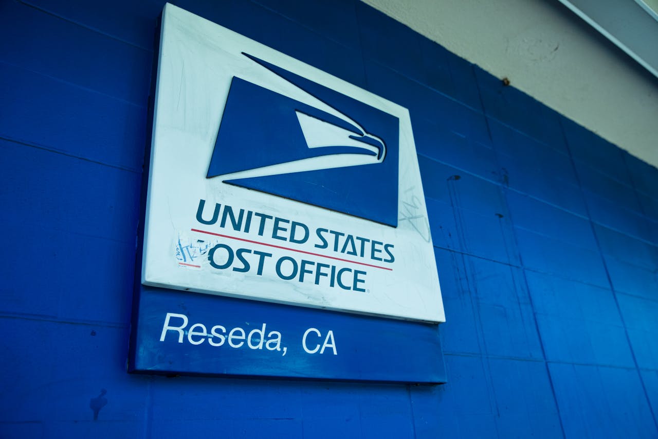 get-in-touch Close-up of the United States Post Office sign against a blue wall in Reseda, CA.